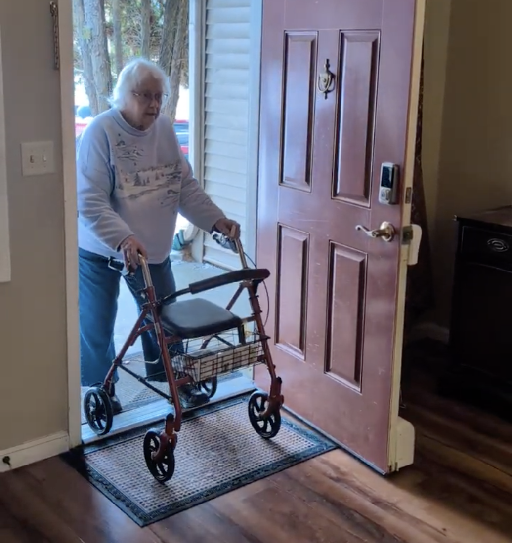 Woman with walker entering through a door with Theodoor